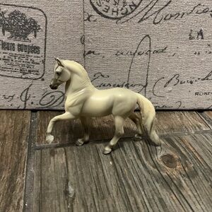 A bryer horse with a white and gray coat and mane and tail